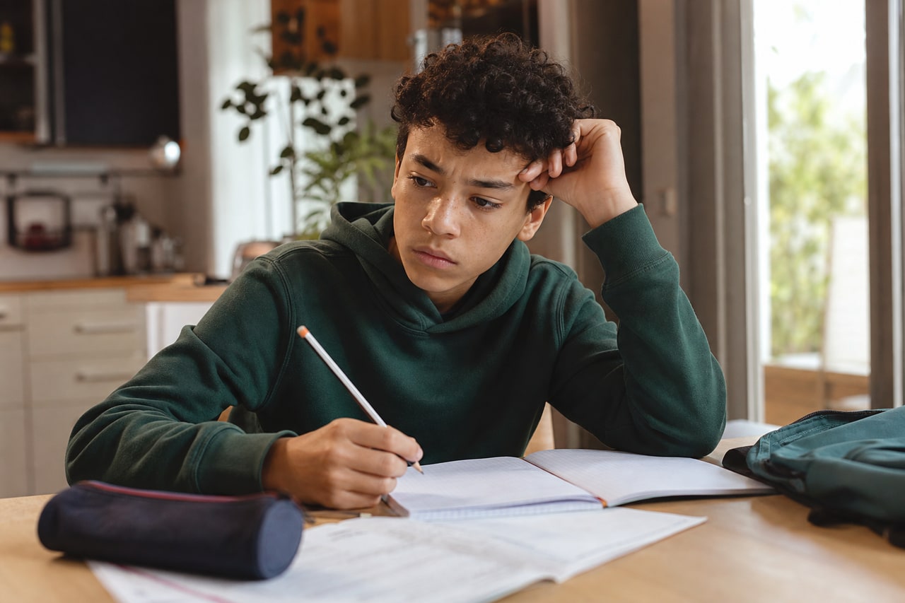 Un adolescent découragé peine à se concentrer sur son travail scolaire